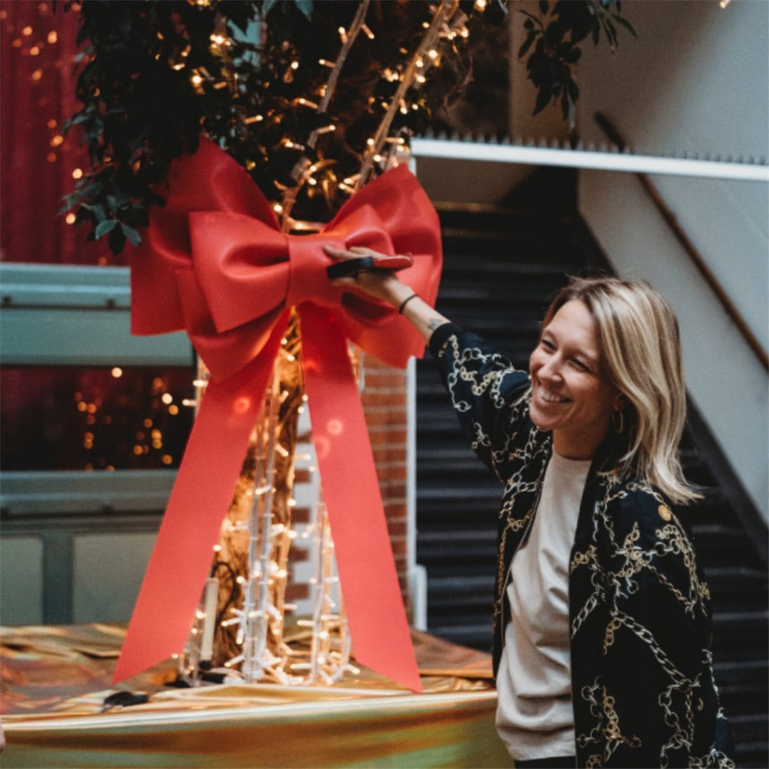 Iris hangt een grote rode strik op in een kersttafereel