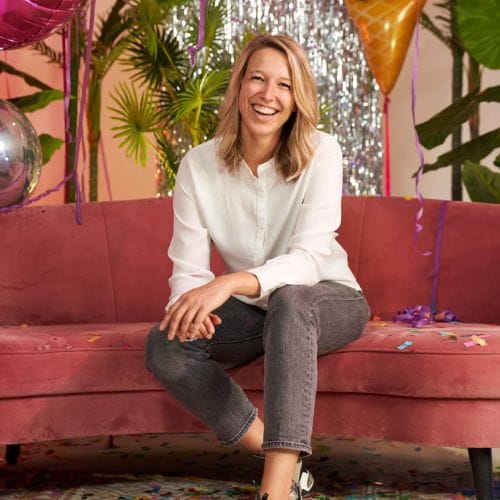 Iris op een roze driezitsbank tussen feestdecoratie