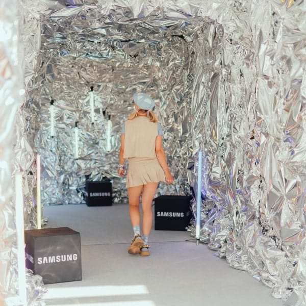 Bezoeker loopt door een zilveren folietunnel op een Samsung-event
